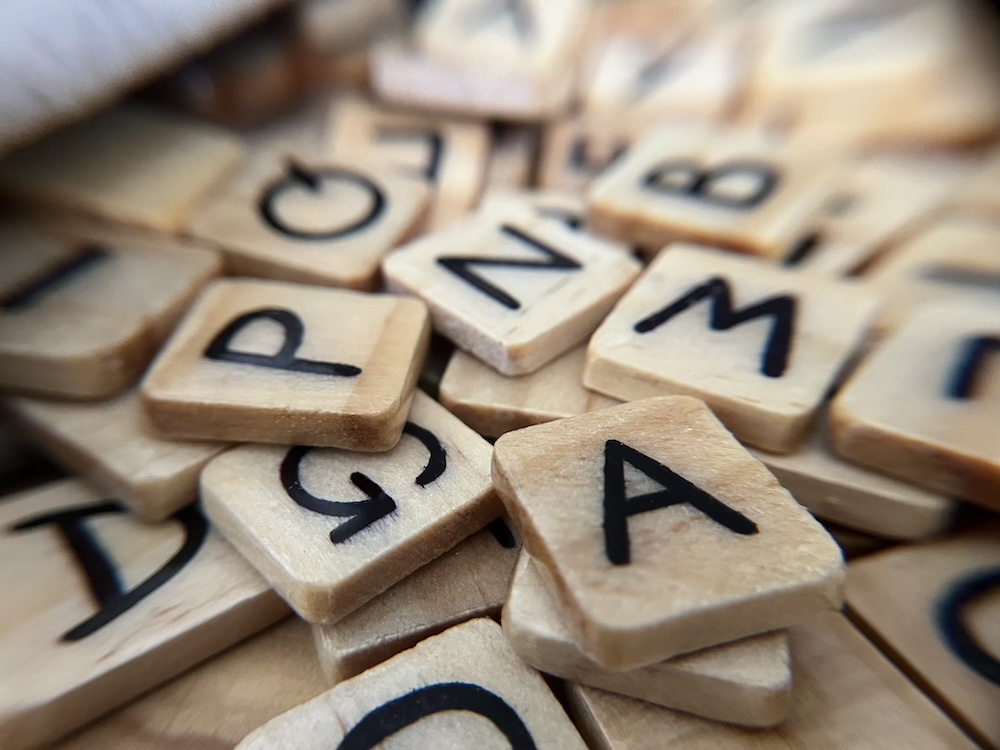 A close up on a pile of Banagrams tiles spilling from a bag.